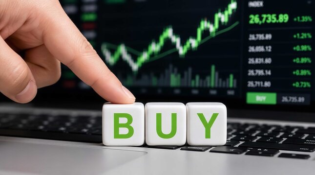 Investor finger pressing white blocks spelling buy on a laptop keyboard with a green financial stock market chart background display