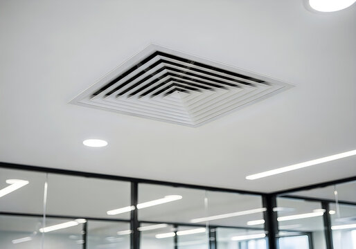 Modern square air vent with angled slats installed on a white suspended ceiling with bright led lights above glass walls