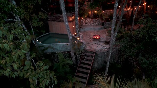 Atmospheric night view of a jungle villa with illuminated deck in Peten, Guatemala.