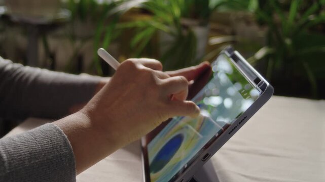 The artist draws on the screen of the tablet, choosing a palette from the interface