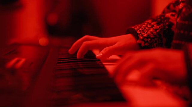 Caucasian teenager hands playing synthesizer keyboard during music rehearsal in studio. Footage is perfect for music school commercials and youth hobby campaigns