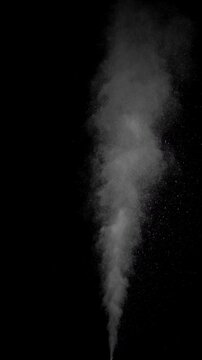 Hot Steam Plume. Slow-motion of hot steam powerfully rising from below, forming a tall turbulent column that expands, gradually dissipates into fine sparkling particles against deep black background.