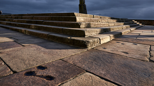 indentations. Empty ancient market square with stone steps showing indentations where a pillory once stood. event programs, museum guides, designed for cultural heritage projects and event programs.