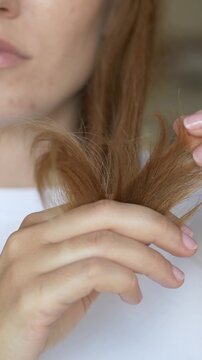Woman holds and examines hair ends checking for split ends and damage in daily haircare concern routine closeup. Footage for hair treatment brand promotion, trichology clinic content, haircare beauty.