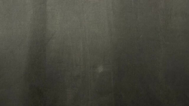 cinematic slow tracking shot revealing raw charcoal slate texture casting moody atmospheric shadows in minimalist studio