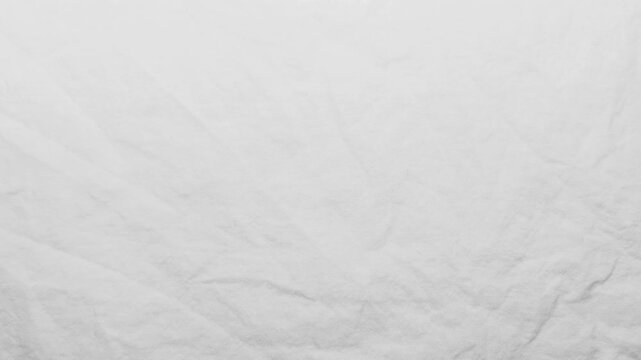 minimalist white linen fabric ripples gently under soft studio light creating serene abstract shadow texture