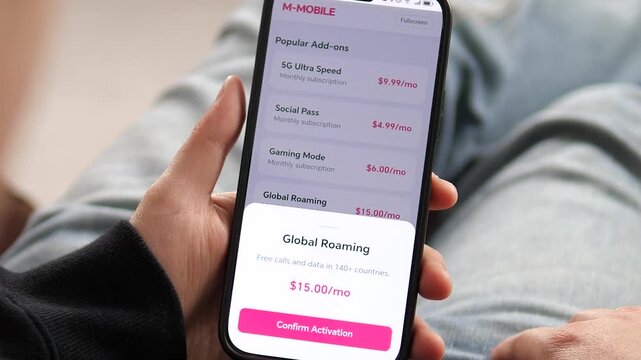 Hands holding a phone with a Global Roaming activation popup on display. The screen shows a pink confirmation button and a clear monthly cost breakdown. Great for showcasing personalization, telecom