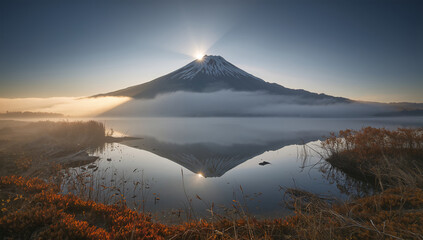 Fototapeta premium 雲海の上に朝日を受けた富士山が湖面へ映る壮大な写真