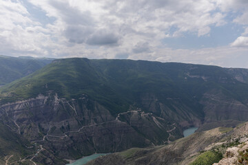 Obraz premium Wide scenic landscape of the Small Sulak Canyon with winding turquoise river, steep rocky slopes and cloudy sky, Dagestan Republic, Russia, Caucasus region