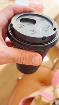 Point of view person holding coffee or hot beverage take away to go cup in office walking towards desk. POV ugc style vertical phone video. Bringing coffee to work in morning routine in business day