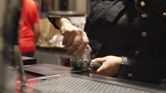 Close-Up of Barista Pressing Coffee Tamper into Portafilter at Professional Specialty Cafe Counter