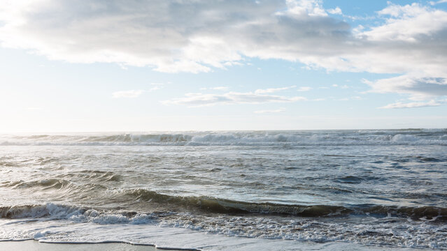 Scenic seascape with rolling ocean waves, foamy surf and dramatic clouds at Khalaktyrsky Beach, Kamchatka Krai, Russia, natural travel destination background