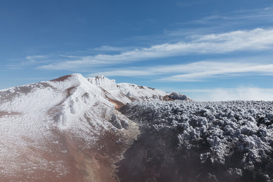 Scenic view of Avachinsky Volcano with snow-covered crater ridge and volcanic rocks under clear blue sky, Kamchatka Krai, Russia, remote wilderness travel scene