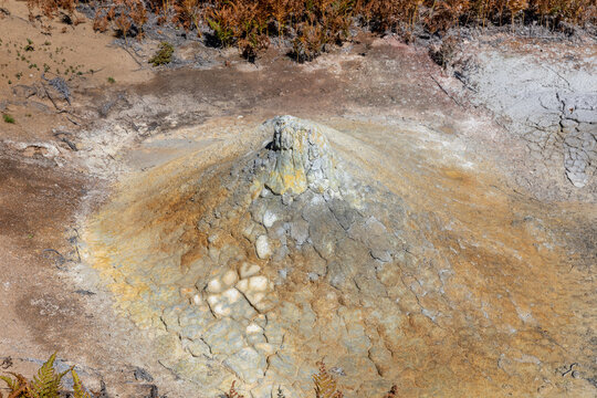 Close-up view of a mud volcano cone with mineral deposits and cracked geothermal clay, in Uzon Caldera, Kamchatka Krai, Russia, volcanic landscape
