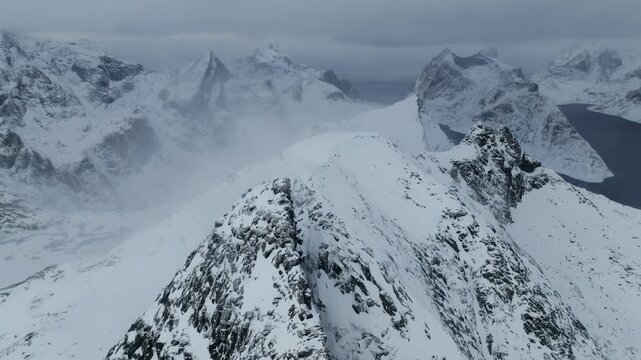 Snow-covered jagged mountain peak with surrounding alpine ridges