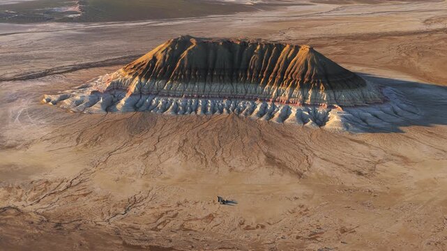 Aerial view of Mount Bokty showing its unique colorful geological layers and eroded slopes in the desert of Karakiya District, Mangystau Region, Kazakhstan.