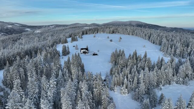 Aerial panoramic orbit showing mountain pasture chalet surrounded by pine forest with Pilsko and Rysianka peaks