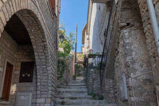 Ulcinj, Montenegro - August 10, 2025: Quiet stone stairway between old houses in Ulcinj Old Town, a historic coastal quarter in Ulcinj, Montenegro, under clear blue sky