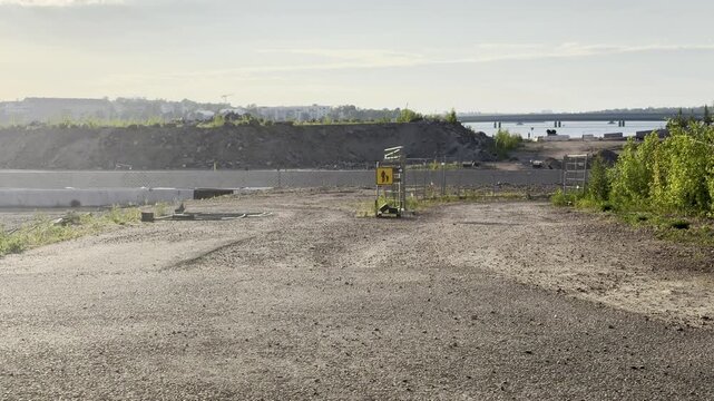 Empty Building Plot with Sand and Pedestrian Sign in J&auml;tk&auml;saari Under Summer Afternoon Light