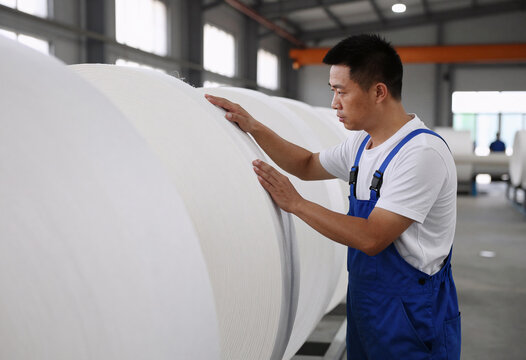 Paper Mill Worker Inspecting Cellulose Coils