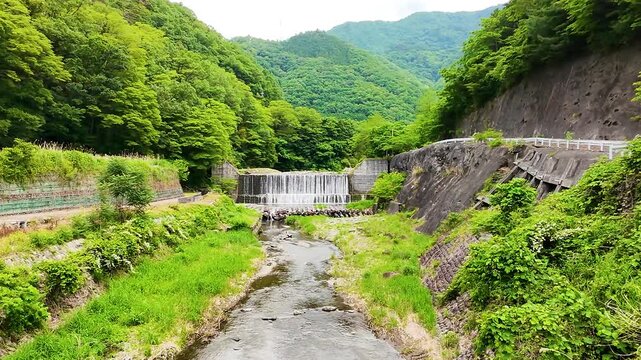 山から続く透明な川の流れと森林に包まれた爽やかなドローンイメージ