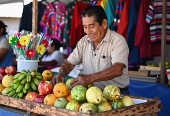 Fototapeta premium Mexican Fruit Vendor Smiling at Traditional Market