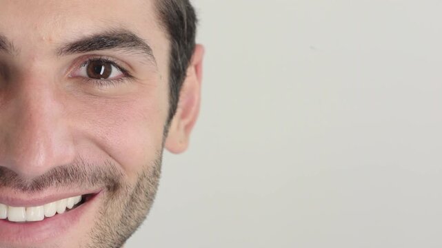 Man, face and studio with eyes for awareness, optometry or eyesight on a white background. Half, portrait or male person with smile, teeth or positive attitude for health or wellness on mockup space