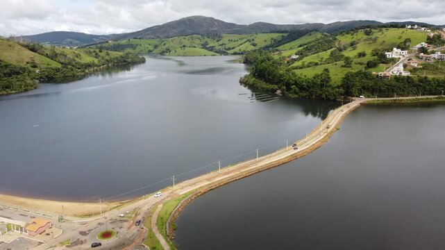 Aerial view of Capit&oacute;lio, Brazil, featuring the city sign, urban landscape, and the famous Furnas Lake surrounded by rolling hills, scenic countryside, and natural beauty.
