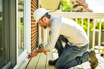 Fototapeta premium Construction worker uses sealant gun during window installation
