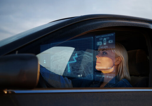 Driver using futuristic hologram GPS navigation in a car at dusk