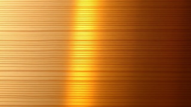 Bronze surface with brushed texture, highlighted by warm lighting in a detailed close-up.