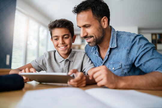 Father and son using tablet and doing homework