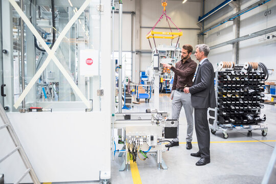 Two businessmen talking in a factory