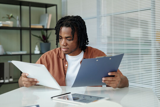 Manager analyzing documents at a desk in an office setting