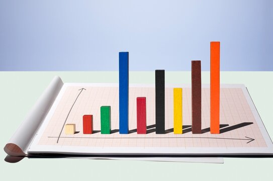 Multi colored wooden rods forming a bar chart on graph paper