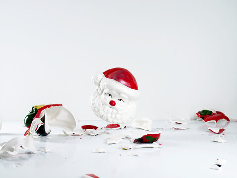 Shattered porcelain Santa Claus figure falling on white background