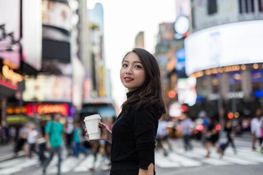 USA, New York City, Manhattan, young woman with coffee to go on the street