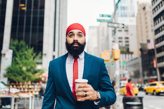 Indian businessman walking in Manhattan, drinking coffee