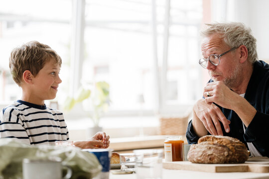 Father and son having a serious talk during breakfast indoors