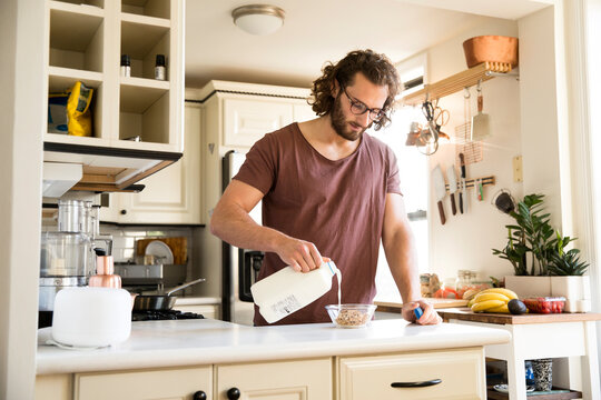 Man preparing muesli in his kitchen