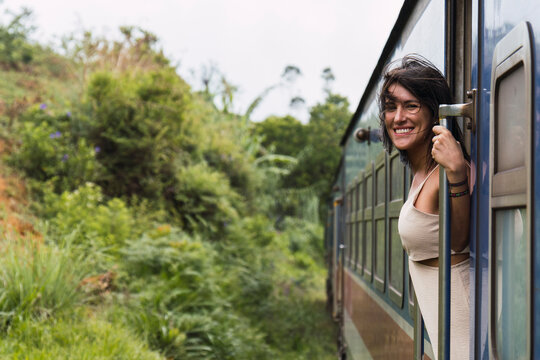 Smiling woman enjoying an iconic train ride through Ella nature