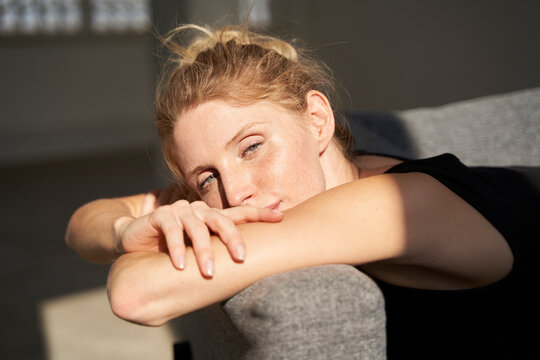 Woman resting on sofa in sunshine