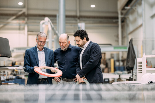 Engineers discussing a product design in a factory setting