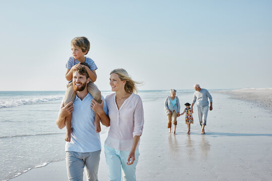 Happy extended family strolling on the beach
