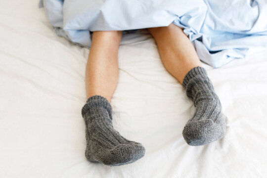 Woman with socks on bed at home