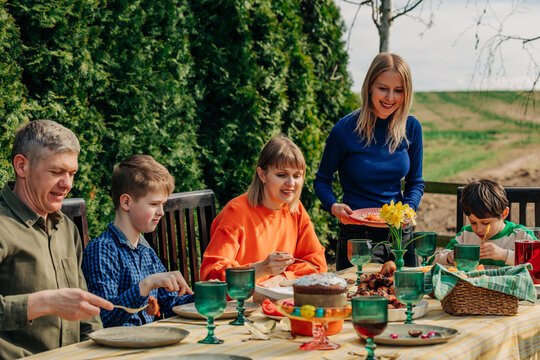Family enjoying a joyful outdoor Orthodox Easter dinner in backyard