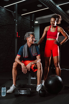 Fit senior man in the gym with his personal trainer.