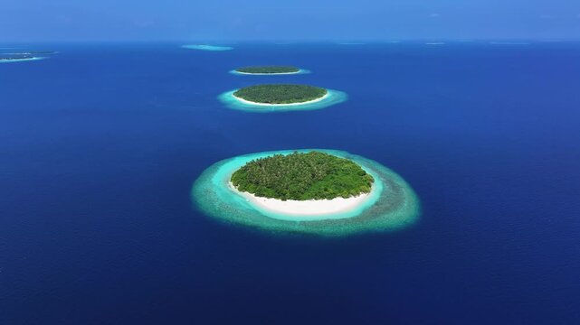 Aerial view of lush tropical islands with white sand beaches and turquoise coral reefs in the deep blue ocean Kendhoo, Baa Atoll, Maldives.