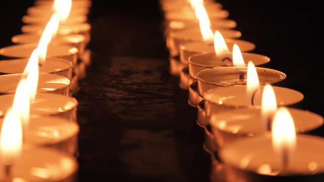 Candles are lit in a row during a gathering in a dim room on a quiet evening