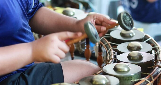 Hands playing traditional Thai gong circle instrument, khongwong, close-up. Ideal for culture, music education, performance, and traditional Thai art concepts